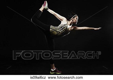 Young woman standing on one leg View Large Photo Image Stock Photo - Young woman standing on one leg. Fotosearch