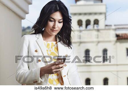 Young woman texting on smartphone View Large Photo Image Stock Photo - Young woman texting on smartphone. Fotosearch