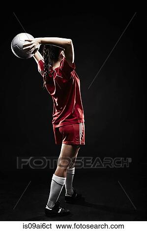 Stock Photograph - Young woman throwing football. Fotosearch