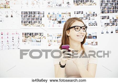 Young woman using cell phone in creative studio View Large Photo Image Stock Photo - Young woman using cell phone in creative studio. Fotosearch