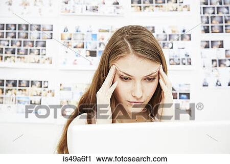 Young woman using computer rubbing head View Large Photo Image Stock Image - Young woman using computer rubbing head. Fotosearch