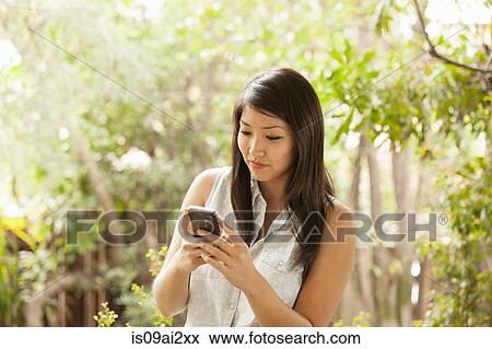 Young woman using smart phone View Large Photo Image Stock Photo - Young woman using smart phone. Fotosearch