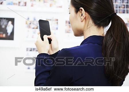 Young woman using smartphone View Large Photo Image Stock Image - Young woman using smartphone. Fotosearch