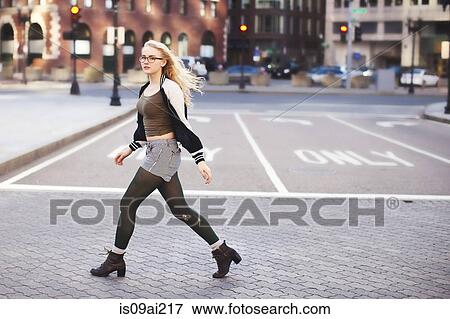 Stock Photo - Young woman walking down street. Fotosearch