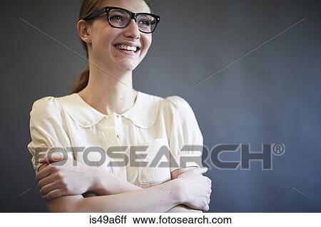 Stock Image - Young woman wearing blouse and glasses, studio shot. Fotosearch