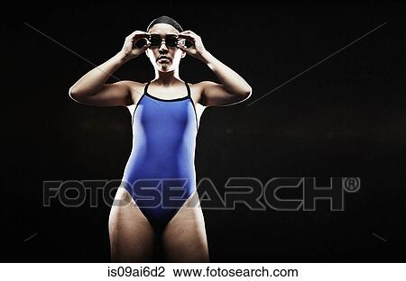 Young woman wearing blue swimsuit putting on goggles View Large Photo Image Stock Image - Young woman wearing blue swimsuit putting on goggles. Fotosearch