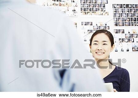 Young woman with colleague in creative studio View Large Photo Image Stock Photo - Young woman with colleague in creative studio. Fotosearch