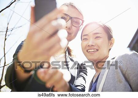 Young women using smartphone View Large Photo Image Stock Photograph - Young women using smartphone. Fotosearch