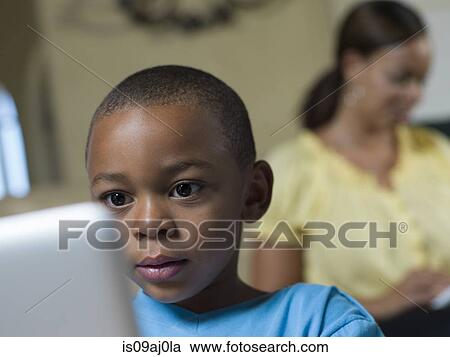Boy using laptop in sitting room View Large Photo Image Stock Image - Boy using laptop in sitting room. Fotosearch
