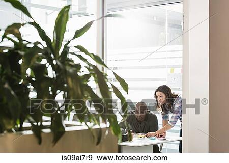 Business colleagues preparing work in office View Large Photo Image Stock Photo - Business colleagues preparing work in office. Fotosearch
