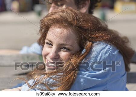 Stock Photo - Close up portrait of young woman in boyfriends arms. Fotosearch