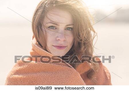 Stock Photo - Close up portrait of young woman wrapped in blanket. Fotosearch