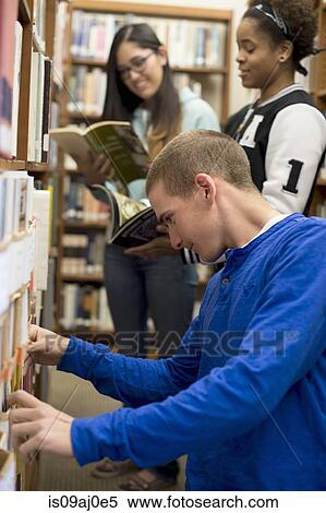 Stock Photography - College students choosing books in library. Fotosearch