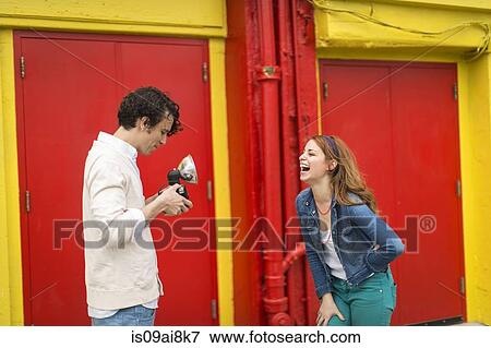 Couple having a laugh whilst taking photograph View Large Photo Image Stock Photo - Couple having a laugh whilst taking photograph. Fotosearch