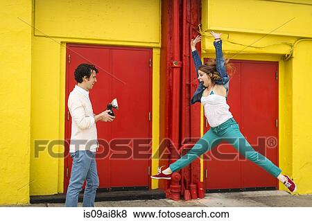 Couple having fun whilst taking photograph View Large Photo Image Stock Photo - Couple having fun whilst taking photograph. Fotosearch