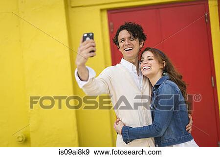 Stock Photo - Couple taking selfie on smartphone. Fotosearch