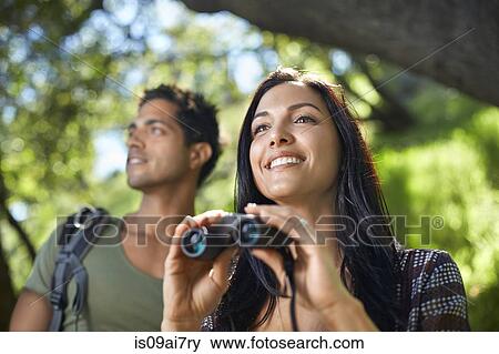 Couple with binoculars birdwatching in forest View Large Photo Image Stock Photo - Couple with binoculars birdwatching in forest. Fotosearch