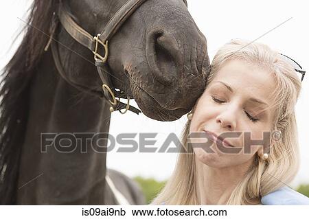 Cropped close up of horse touching mature woman's face View Large Photo Image Stock Image - Cropped close up of horse touching mature woman's face. Fotosearch