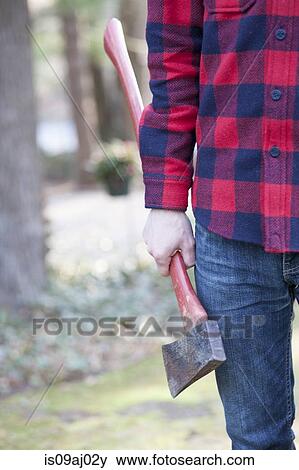 Cropped image of mid adult man in forest holding an axe View Large Photo Image Stock Photo - Cropped image of mid adult man in forest holding an axe. Fotosearch