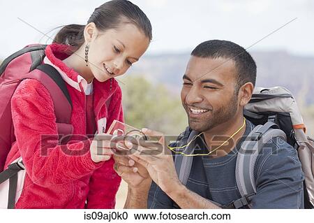 Stock Image - Father and daughter looking at compass whilst out hiking, Sedona, Arizona, USA. Fotosearch