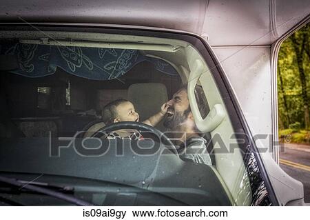 Father and toddler daughter playing together in car View Large Photo Image Stock Photo - Father and toddler daughter playing together in car. Fotosearch