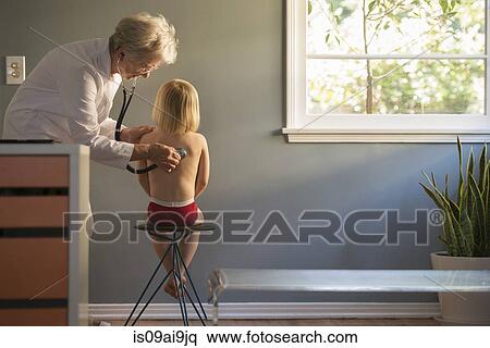 Female doctor listening to stethoscope on boys back in doctors office View Large Photo Image Stock Photography - Female doctor listening to stethoscope on boys back in doctors office. Fotosearch