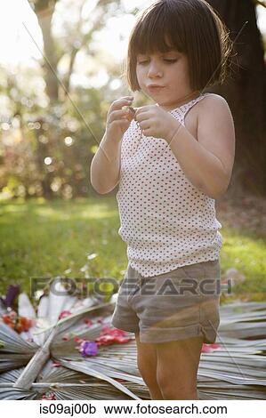 Stock Image - Girl holding green anole lizard in garden. Fotosearch