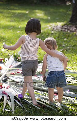 Girl with arm around toddler sister with flower and leaf display in garden View Large Photo Image Stock Image - Girl with arm around toddler sister with flower and leaf display in garden. Fotosearch