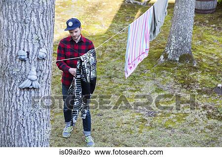 High angle view of mid adult man hanging out laundry in garden View Large Photo Image Picture - High angle view of mid adult man hanging out laundry in garden. Fotosearch