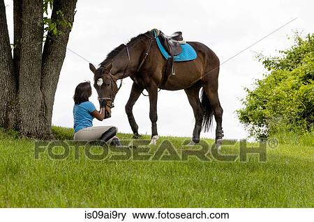 Horse rider sitting beside tree, horse beside View Large Photo Image Stock Photo - Horse rider sitting beside tree, horse beside. Fotosearch