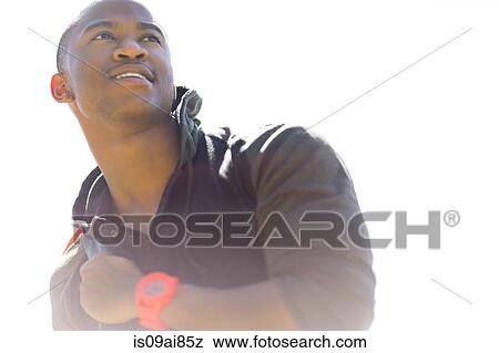 Low angle portrait of smiling young man View Large Photo Image Stock Photo - Low angle portrait of smiling young man. Fotosearch