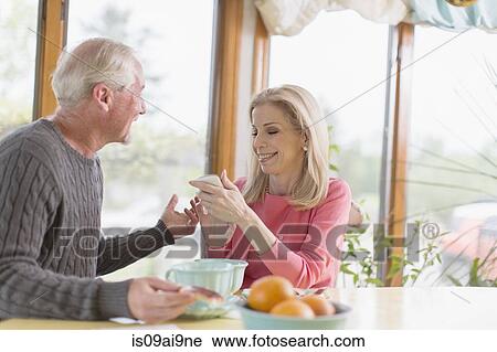 Mature couple chatting about text message on smartphone View Large Photo Image Stock Image - Mature couple chatting about text message on smartphone. Fotosearch