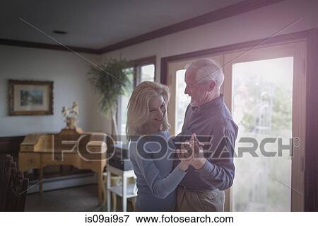 Stock Photo - Mature couple waltzing together in dining room. Fotosearch