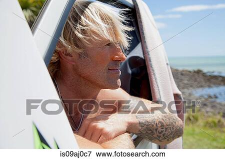 Mature man looking out of vehicle window at beach View Large Photo Image Stock Photo - Mature man looking out of vehicle window at beach. Fotosearch