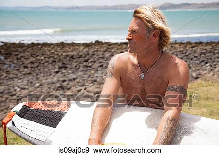Mature man with surfboard on beach View Large Photo Image Stock Photo - Mature man with surfboard on beach. Fotosearch