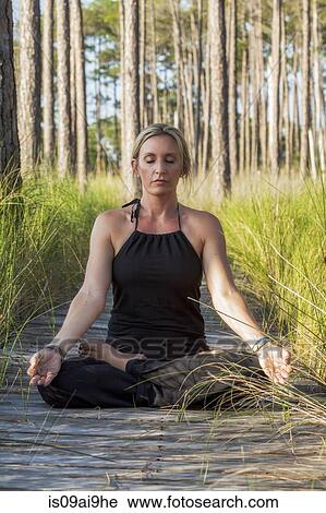 Mature woman practicing yoga meditation on forest walkway View Large Photo Image Stock Image - Mature woman practicing yoga meditation on forest walkway. Fotosearch