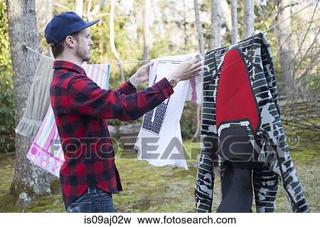 Mid adult man hanging out laundry in garden View Large Photo Image Stock Photo - Mid adult man hanging out laundry in garden. Fotosearch