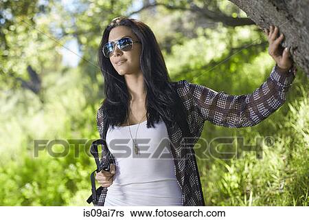 Stock Photograph - Mid adult woman out walking in forest. Fotosearch