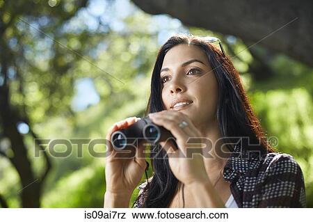 Mid adult woman with binoculars birdwatching in forest View Large Photo Image Stock Photo - Mid adult woman with binoculars birdwatching in forest. Fotosearch