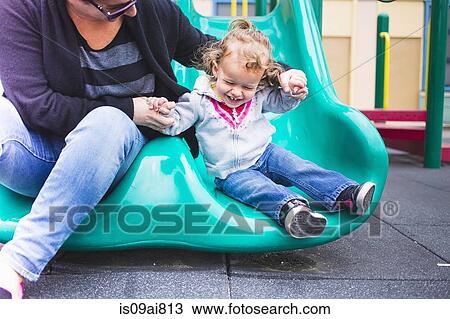 Mother and daughter going down slide in playground View Large Photo Image Stock Image - Mother and daughter going down slide in playground. Fotosearch