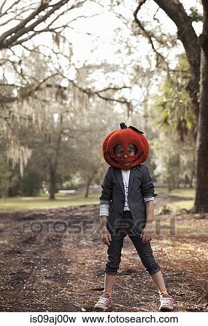 Portrait of boy in forest wearing pumpkin head View Large Photo Image Stock Photo - Portrait of boy in forest wearing pumpkin head. Fotosearch