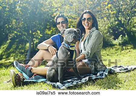 Portrait of couple and dog sitting on picnic blanket in park View Large Photo Image Stock Photography - Portrait of couple and dog sitting on picnic blanket in park. Fotosearch