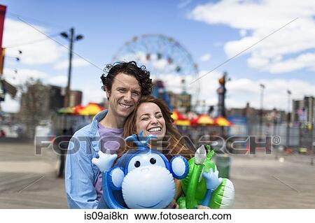 Picture - Portrait of couple and inflatable monkeys at amusement park. Fotosearch