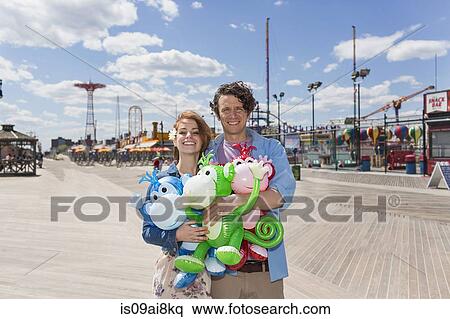 Portrait of couple with inflatable monkeys at amusement park View Large Photo Image Stock Photography - Portrait of couple with inflatable monkeys at amusement park. Fotosearch