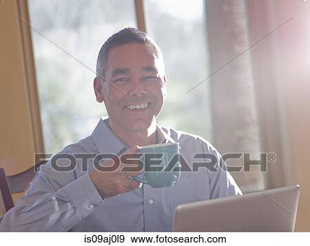 Portrait of smiling mature man with coffee and laptop View Large Photo Image Stock Photo - Portrait of smiling mature man with coffee and laptop. Fotosearch