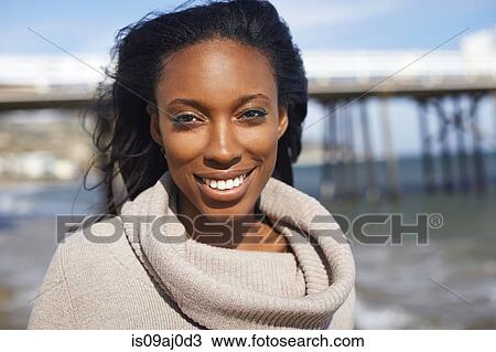 Stock Image - Portrait of smiling young woman at beach, Malibu, California, USA. Fotosearch