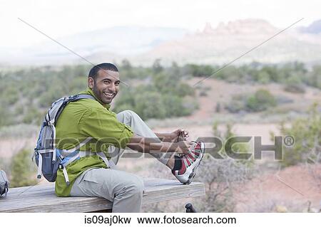 Portrait of young male hiker tying shoelaces, Sedona, Arizona, USA View Large Photo Image Stock Photo - Portrait of young male hiker tying shoelaces, Sedona, Arizona, USA. Fotosearch