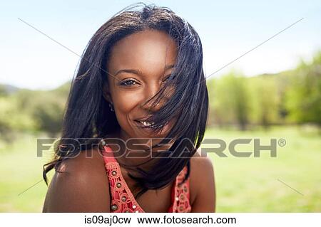 Portrait of young woman with hair blown across her face View Large Photo Image Stock Photo - Portrait of young woman with hair blown across her face. Fotosearch