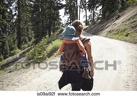 Rear view of mother carrying toddler in baby carrier View Large Photo Image Stock Image - Rear view of mother carrying toddler in baby carrier. Fotosearch
