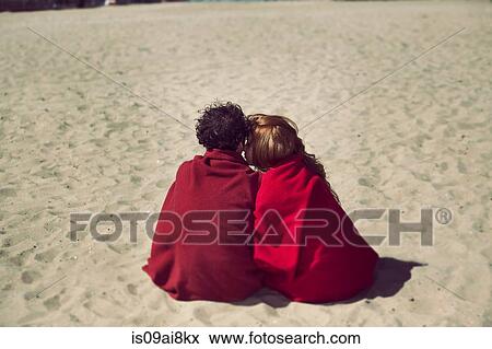 Rear view of romantic couple wrapped in blankets on beach View Large Photo Image Stock Photo - Rear view of romantic couple wrapped in blankets on beach. Fotosearch